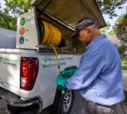 SpringGreen technician unraveling hose from SpringGreen truck to do pest work