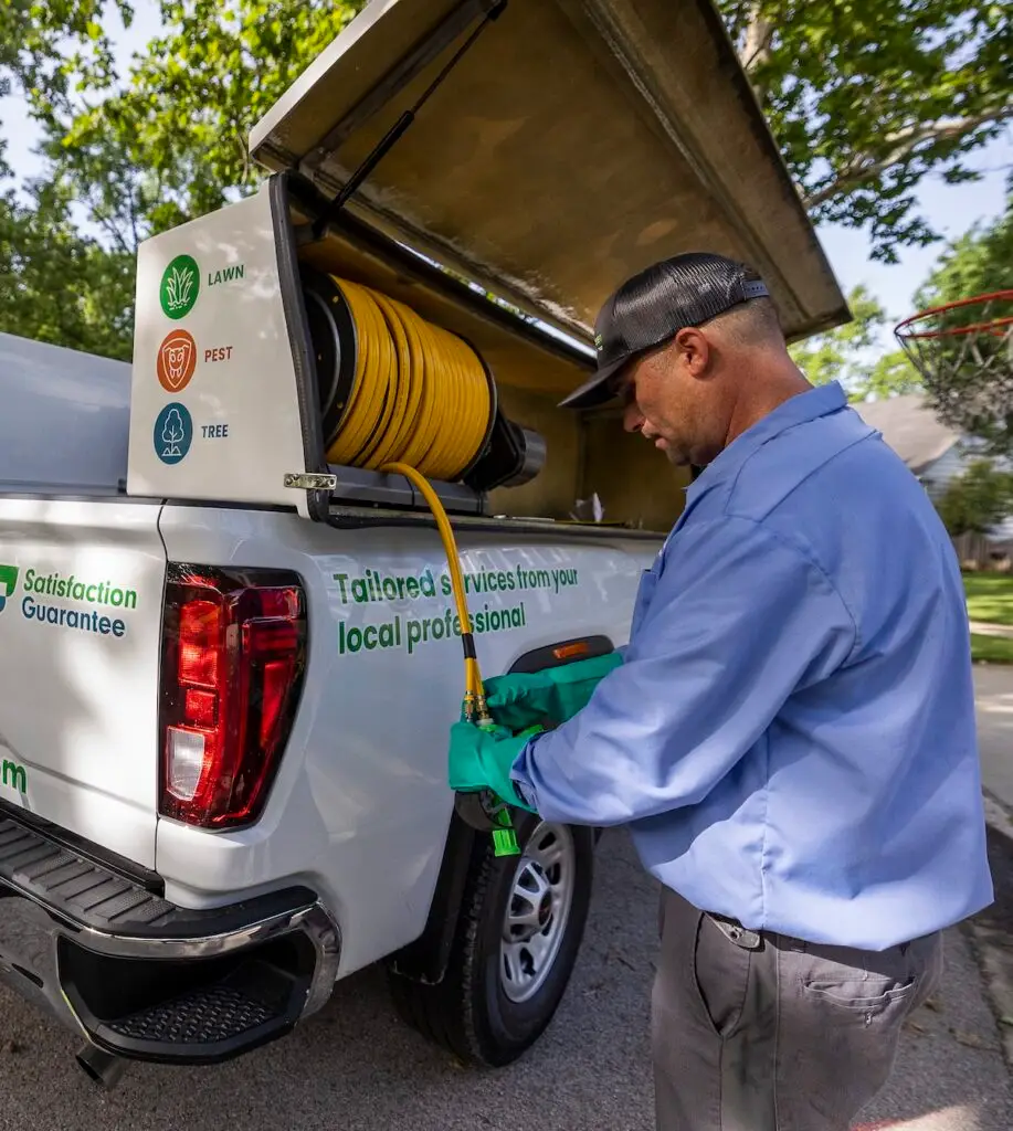 SpringGreen technician unraveling hose from SpringGreen truck to do pest work