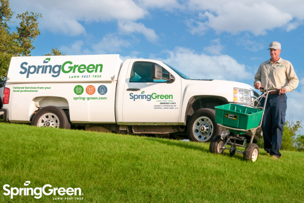 SpringGreen franchise owner delivering lawn care services behind SpringGreen truck
