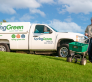 SpringGreen employee doing lawncare in front of SpringGreen truck